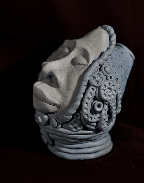 Polymer Clay sculpture of head, draped in coilds and decorative motifs by artist Hollis Richardson